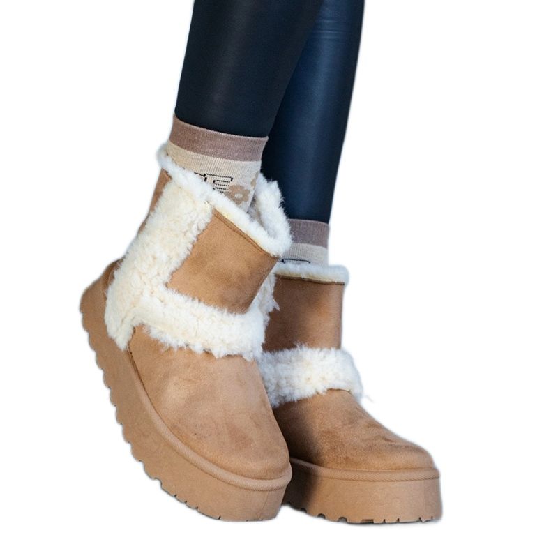 Mörkbeige snöstövlar i ekomocka på en plattform dekorerad med päls från Peters