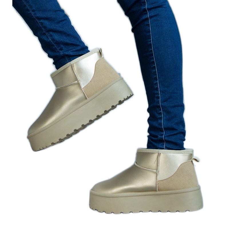 Gyllene låga snöstövlar på plattformen