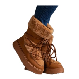 Bruna isolerade snöstövlar dekorerade med päls