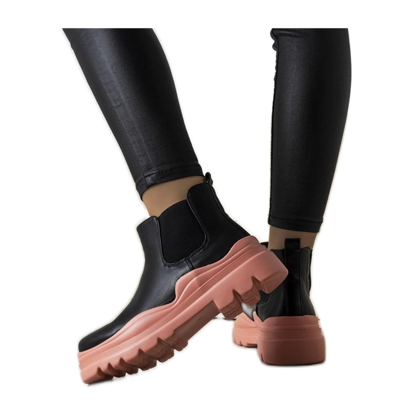 Svarta stövlar på en rosa plattform
