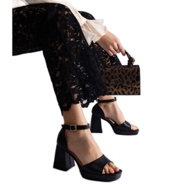 Svarta kvinnosandaler på en massiv häl