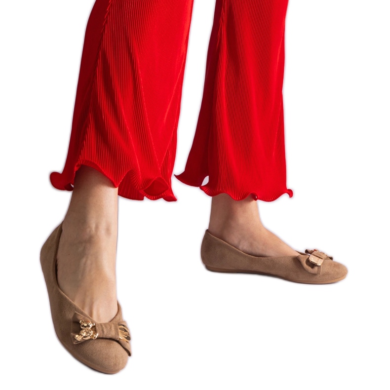 Beige balettlägenheter dekorerade med rosett och brosch