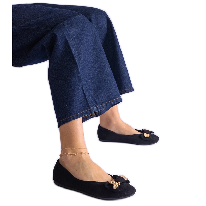 Svarta balettlägenheter dekorerade med rosett och brosch