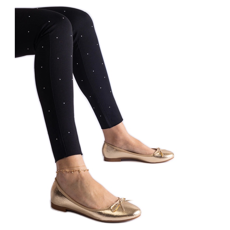 Ballerinaskor i guld dekorerade med rosett gyllene