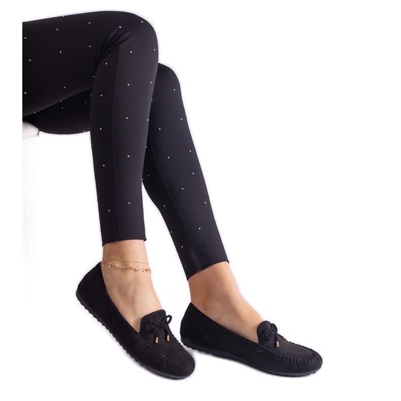 Svarta kvinnors loafers med en båge