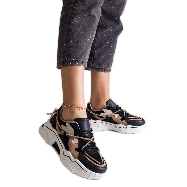 Svarta sneakers dekorerade med ett zirkonsnöre