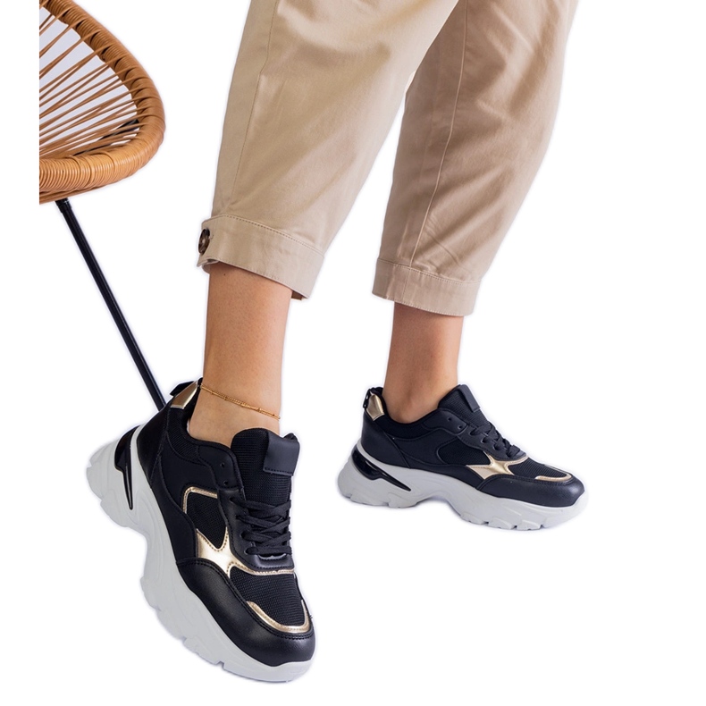 Svarta sneakers på en massiv sula