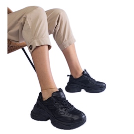 Svarta sneakers på en massiv sula