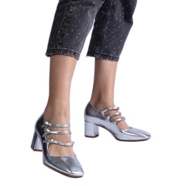 Silverpumpar på en stolpe med dekorativa metallspännen