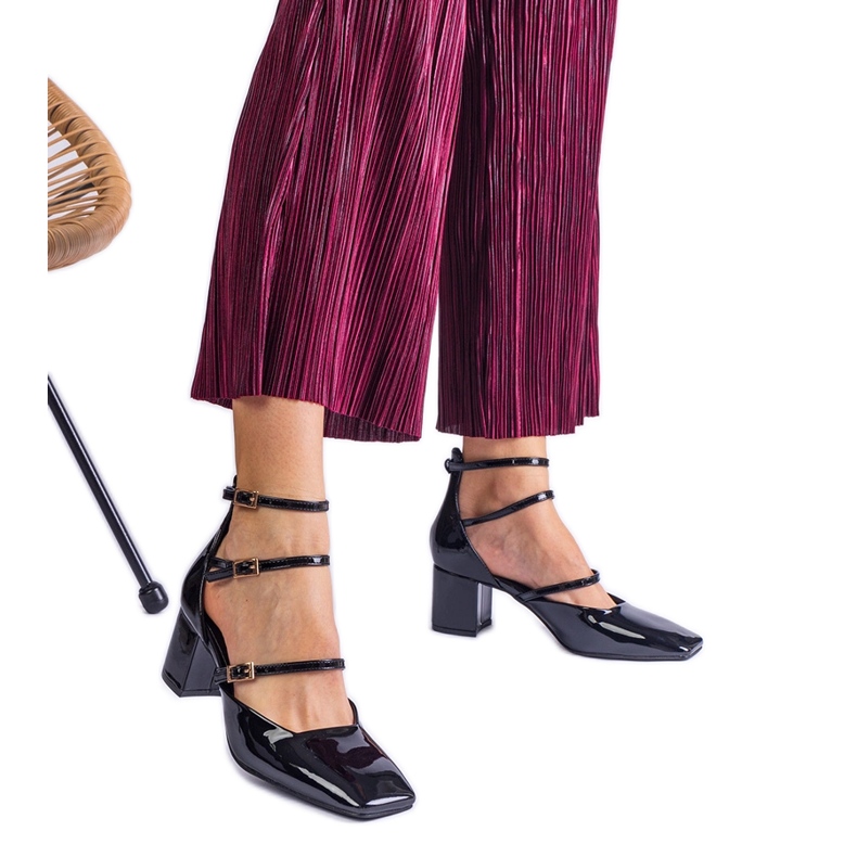 Svarta pumpar lackade på ett inlägg med spännen