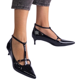 Svarta pumpar lackade på en låg hög med spännen