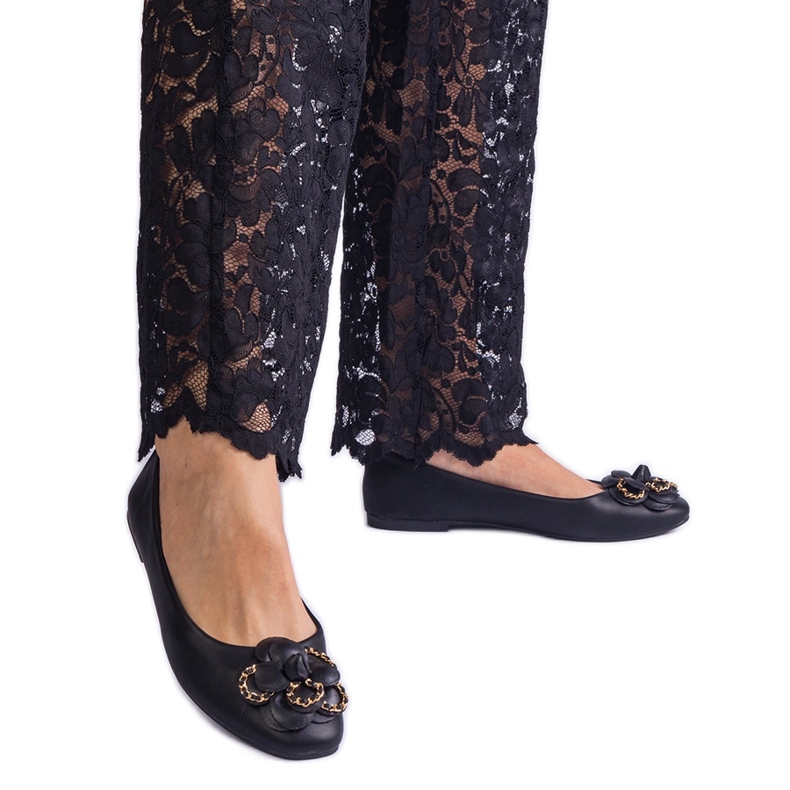 Svarta ballerinor dekorerade med en blomma