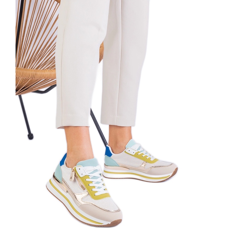 Gröna sportsneakers på plattformen med en gyllene införande