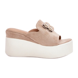 Tofflor på plattformen och kilarna med beige prydnad