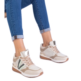 Beige kvinnors sneakers på en dold kil
