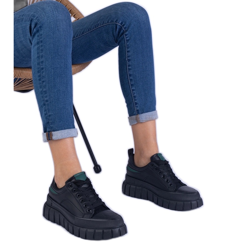 Svarta kvinnors sneakers på en hög plattform