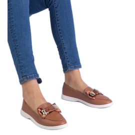 Bruna loafers dekorerade med en båge och en gyllene nallebjörn