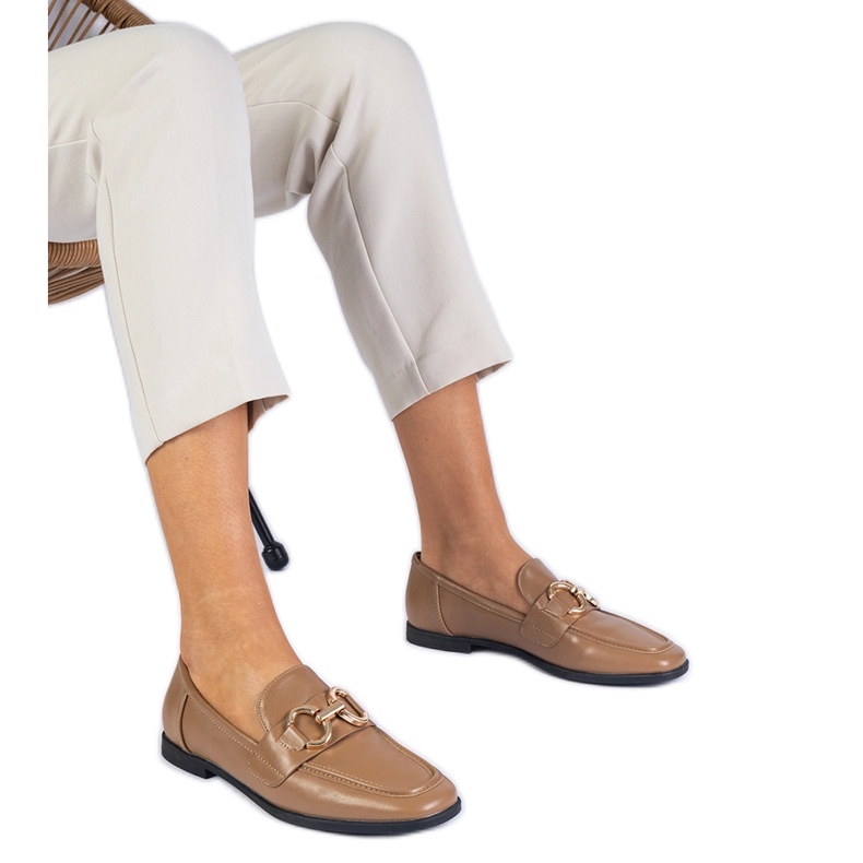Bruna kvinnors loafers med en gyllene dekoration