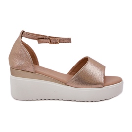 Lätt sandaler på plattformen och delikata guldkilar gyllene