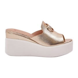 Tofflor på plattformen och kilarna med en gyllene prydnad