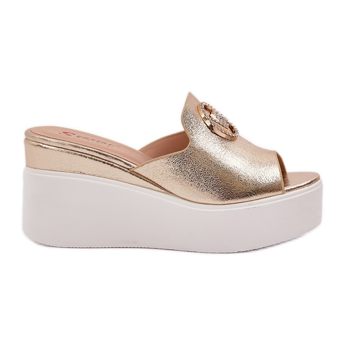 Tofflor på plattformen och kilarna med en gyllene prydnad