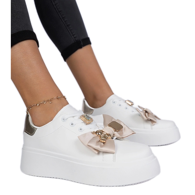 Kvinnors vita och guld sneakers med en båge