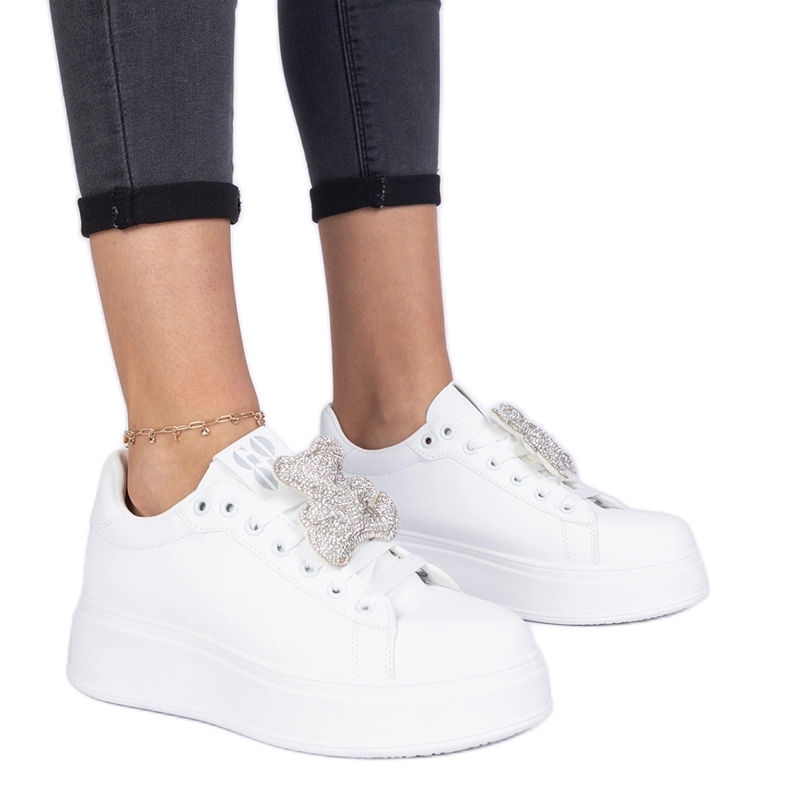 Vita kvinnors sneakers dekorerade med en nallebjörn i strass