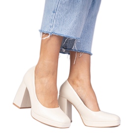 Beige pumpar på ett massivt stolpe med en fyrkantig tå