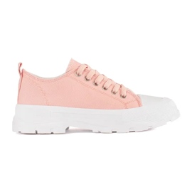 Klassiska sneakers på den ljusrosa plattformen