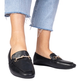 Svarta loafers med en gyllene dekoration och zirkon
