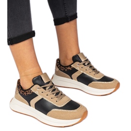 Svarta kvinnors sneakers med glitter med ett djurmönster