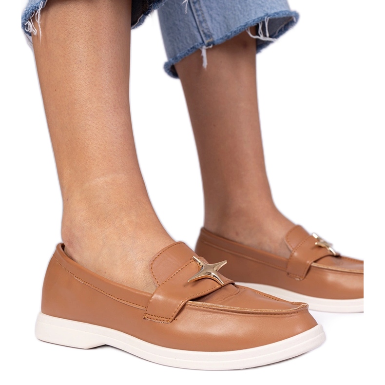 Bruna kvinnors loafers med en gyllene dekoration