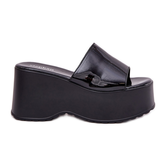 Målade kvinnliga tofflor på plattformen och svarta kilar