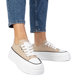 Beige kvinnors sneakers på en hög sula