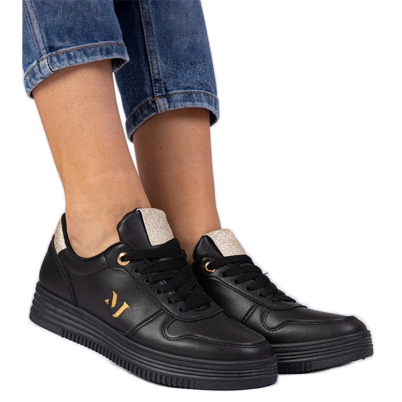 Svarta kvinnors sneakers med gyllene glitter