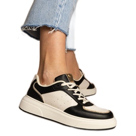 Svarta kvinnors sneakers med ett glittertillbehör