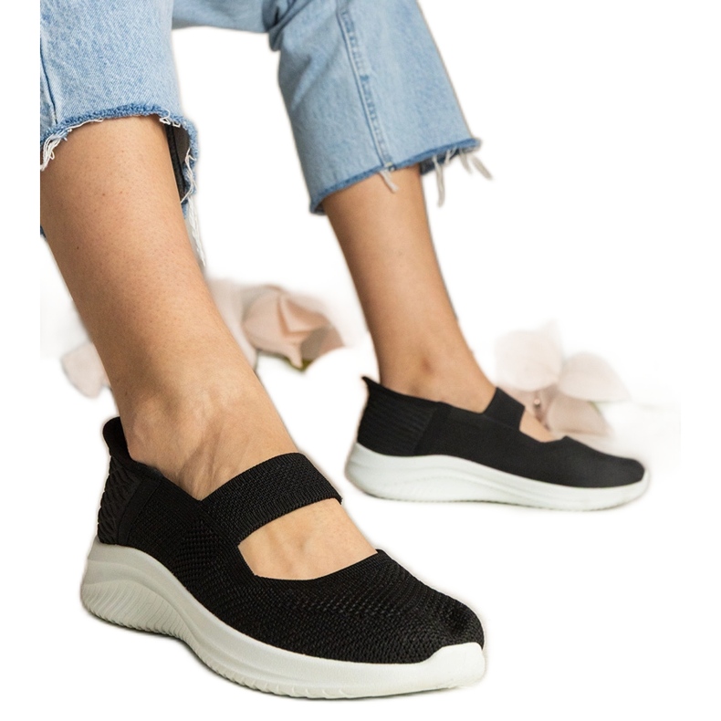 Svarta kvinnors sneakers på en pressad sula