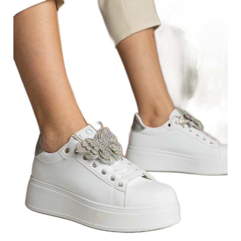 Vita och silver sneakers dekorerade med en fjäril med zirkoner