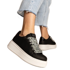 Svarta kvinnors sneakers med massiv snörning =