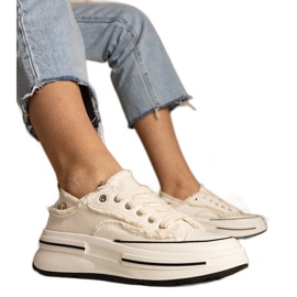 Vita kvinnors sneakers på en hög sula