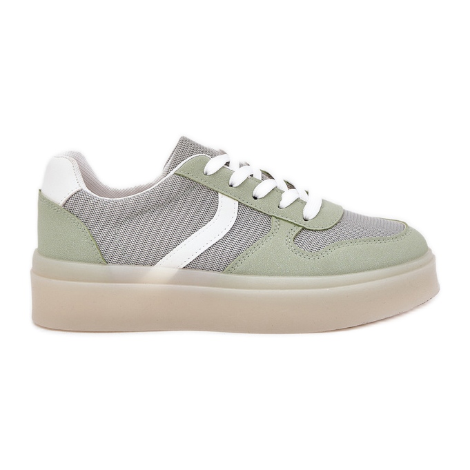 Låga kvinnors sneakers på den gröna plattformen