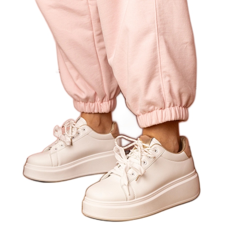 Vita och guldsportsneakers på plattformen