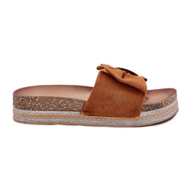 Kvinnors flip flops på plattformen med en båge och en dekorativ kamelbrosch brun