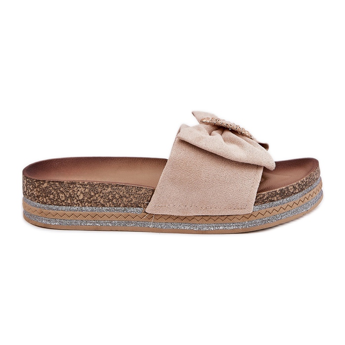 Kvinnors flip flops på plattformen med en båge och en dekorativ brosch beige