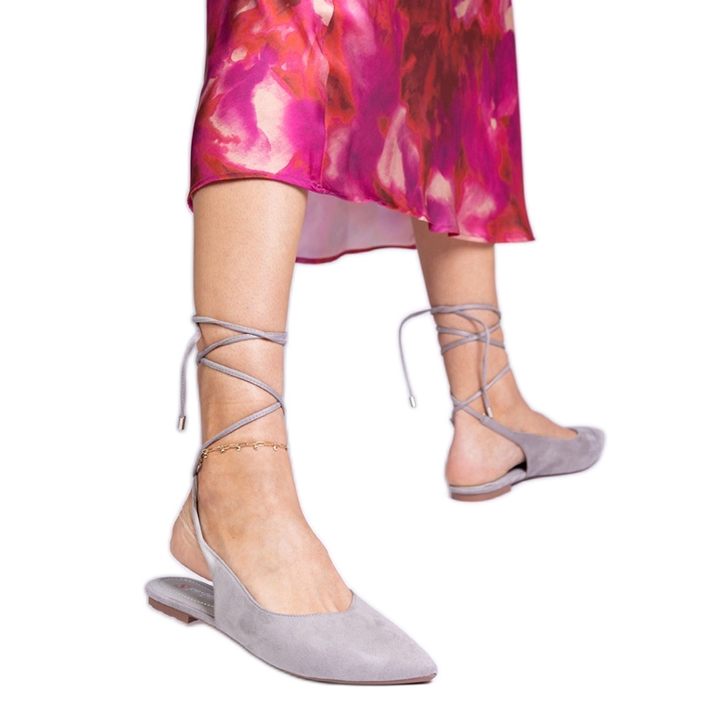 Grå platthelade pumpar bundna på fotleden