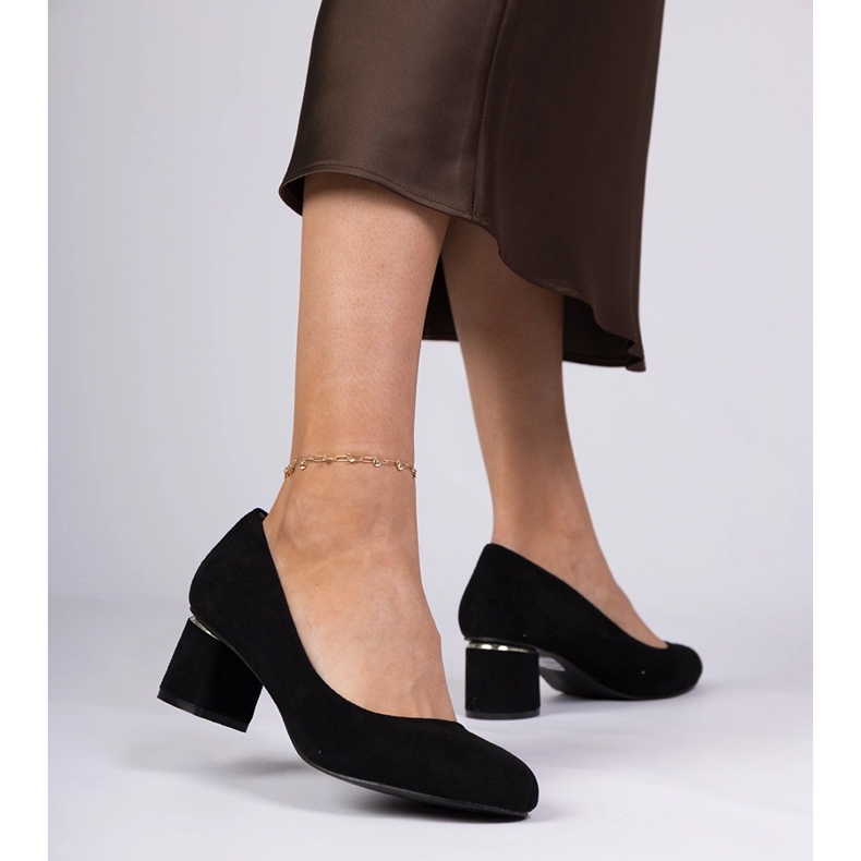 Svarta klassiska pumpar på ett lågt block