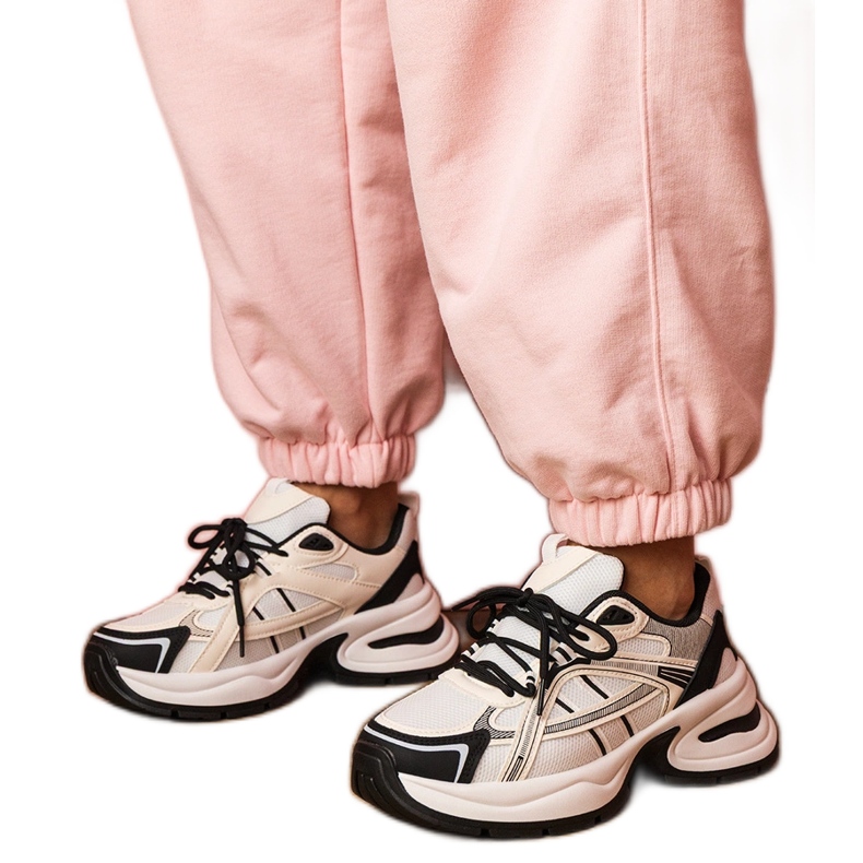Vita och vita sportsneakers på en massiv sula
