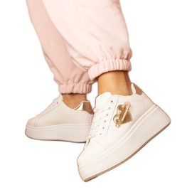 Vita sneakers med ett gyllene hjärta och en zirkonstift