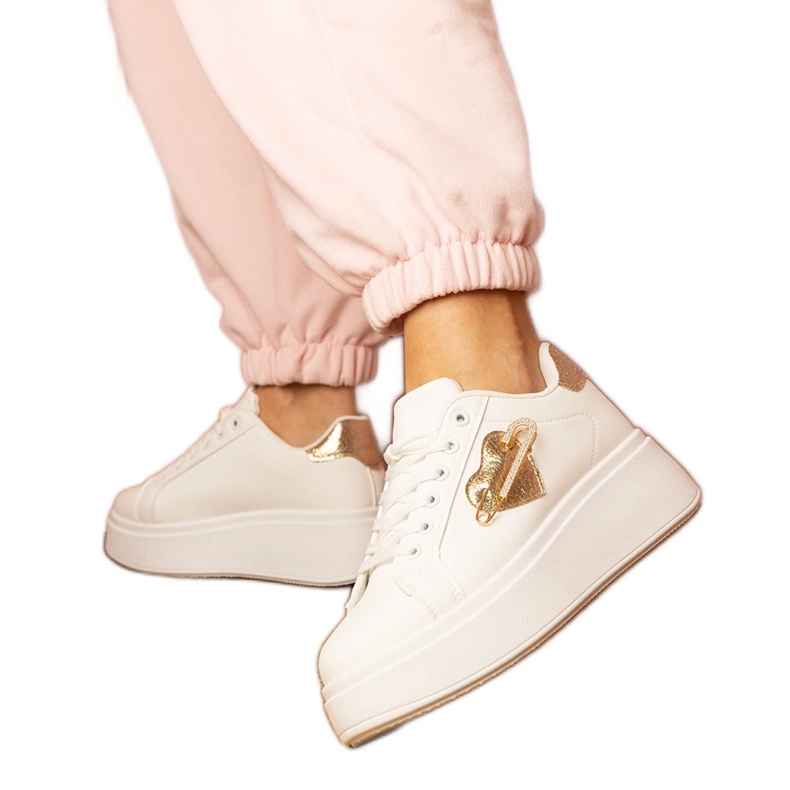 Vita sneakers med ett gyllene hjärta och en zirkonstift
