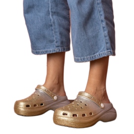 Guld-silver uppbyggda flip-flops på plattformen